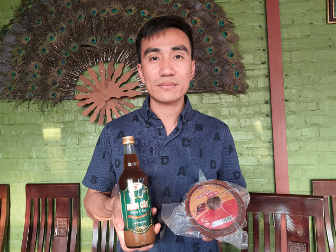 Anh Nguyễn Văn Duy cùng hai sản phẩm được tỉnh Quảng Ninh chứng nhận OCOP là mắm cáy sông Cầm và rươi kho sông Cầm. Ảnh: Cường Vũ
