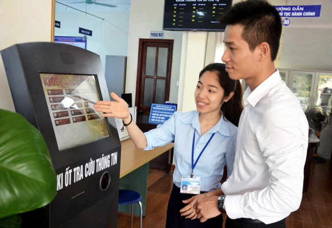 Cán bộ Trung tâm HCC Uông Bí giới thiệu công nghệ mới trong tra cứu thông tin cho chủ doanh nghiệp. Ảnh: Hoàng Nga