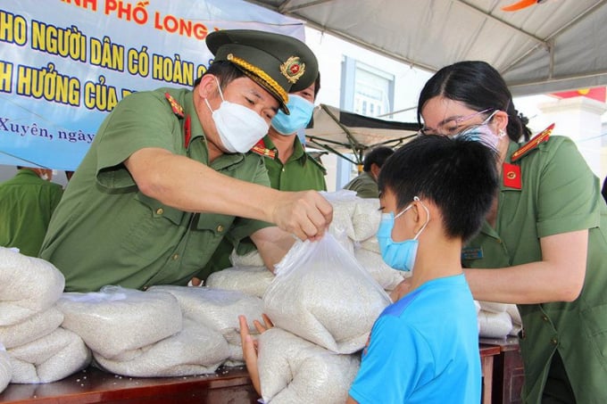 Đại tá Đinh Văn Nơi cùng cán bộ chiến sỹ Công an An Giang trao quà cho người dân khó khăn do ảnh hưởng dịch COVID-19.
