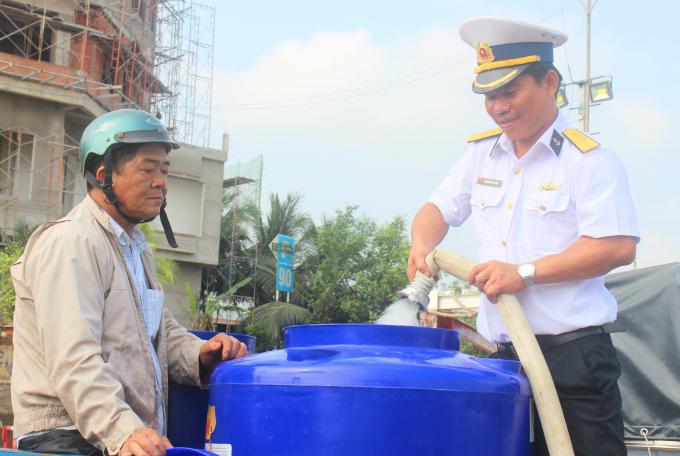 Đại tá Đinh Văn Thắng đang cấp nước cho ông Pham Văn Luận. Ảnh: Minh Đảm.