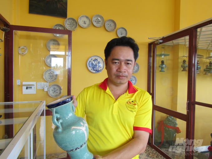 Anh Phạm Văn Hai, chủ quán cà phê Cổ Ngoạn giới thiệu chiếc bình gốm cổ. Ảnh: Thành Hiệp.