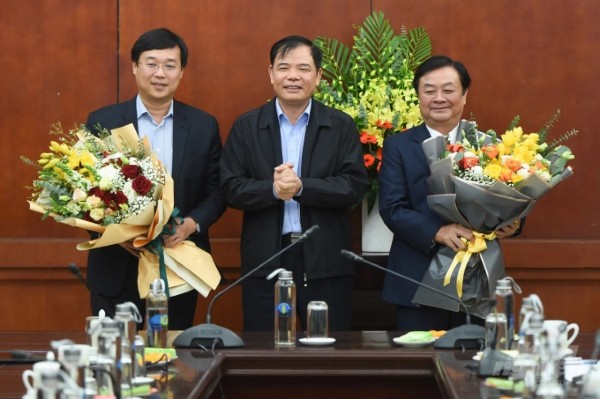 Minister Nguyen Xuan Cuong presents flowers to congratulate newly appointed Deputy Minister of Agriculture and Rural Development Le Minh Hoan and the newly appointed Secretary of Dong Thap Provincial Party Committee Le Quoc Phong (left). Photo: Tung Dinh.