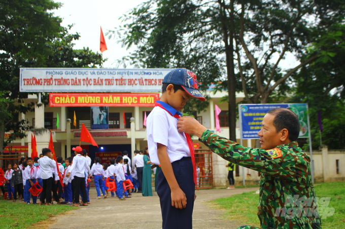 Một học sinh được chiến sĩ Biến phòng đưa đến trường dự lễ khai giảng. Ảnh: Công Điền.