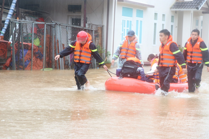 Lực lượng cứu hộ dùng xuồng cao su di chuyển học sinh khỏi vùng ngập lụt. Ảnh: CĐ.