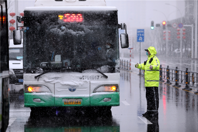 Cảnh sát giao thông điều tiết xe buýt trong mưa tuyết rơi