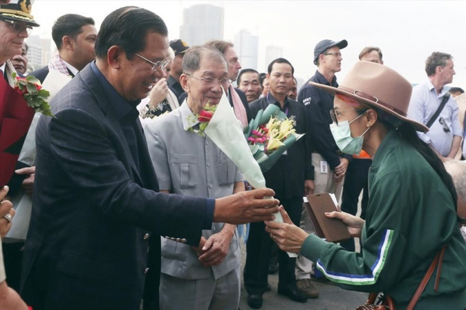 Thủ tướng Campuchia Hun Sen trong trang phục thường ngày tặng hoa các du khách trên chiếc tàu du lịch quốc tế Westerdam có nhiều người nhiễm nCoV. Hành động bất chấp nguy hiểm của ông Hunsen từng gây ra nhiều phản ứng trái chiều, thậm chí còn xuất hiện tin đồn nhà lãnh đạo này cũng bị lây nhiễm bệnh viêm phổi cấp sau buổi gặp gỡ này. Ảnh: ABP