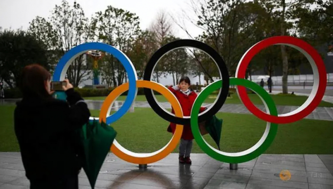 Một phụ nữ tạo dáng chụp ảnh trước biểu tượng Olympic ở thủ đô Tokyo hôm 8/3/2020. Ảnh: Reuters
