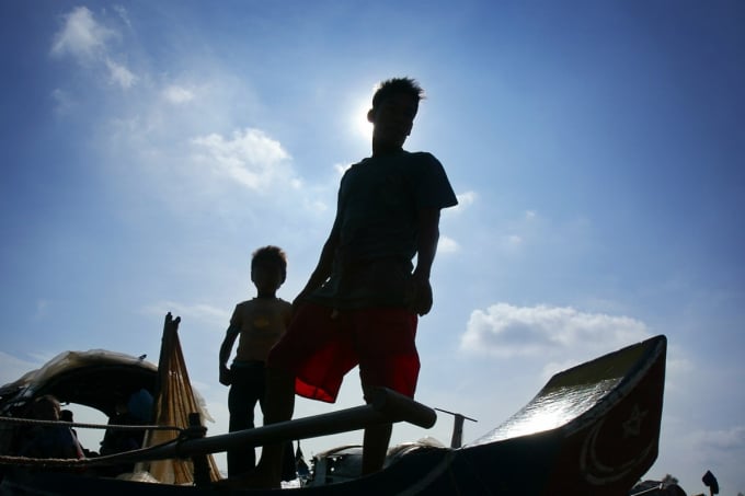 Cha con một ngư dân Campuchia trên chiếc thuyền đánh cá nhỏ trên đoạn sông Mekong đổ vào Biển Hồ. Ảnh: AP
