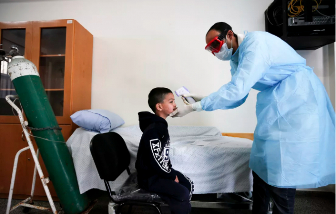 Một trẻ em được đo thân nhiệt ở trại tị nạn thuộc dải Gaza, Palestine hôm 18/3. Ảnh: AFP