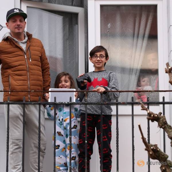 Gia đình anh Fernando ở thủ đô Brussels ra ban công hóng không khí thoáng đãng sau khi bị chính phủ Bỉ áp lệnh phong tỏa hôm 20/3. Ảnh: Reuters