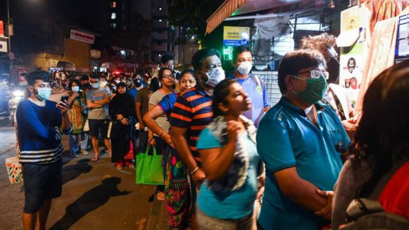 Người dân tại Mumbai xếp hàng chờ mua nhu yếu phẩm trong đêm sau thông báo phong tỏa toàn quốc. Ảnh: AFP