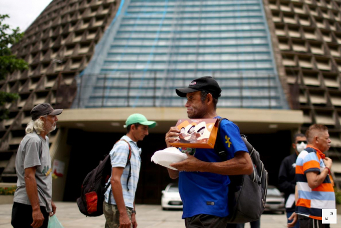 Người vô gia cư xếp hàng nhận đồ phát chẩn ở bên ngoài nhà thờ Sao Sebastiao, thành phố Rio de Janeiro, Brazil hôm 12/4. Ảnh: REUTERS