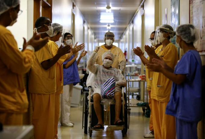 Nữ bệnh nhân người Brazil, Lauro Riff Viegas, 69 tuổi, chào các nhân viên y tế khi được xuất viện hôm cuối tháng 4/2020. Ảnh: Reuters