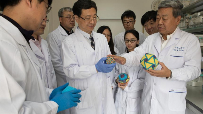 Ông Bu Zhigao (giữa) cùng các nhà nghiên cứu tham quan một phòng thí nghiệm vacxin tả lợn châu Phi hồi cuối tháng 10/2019. Ảnh: Xinhua