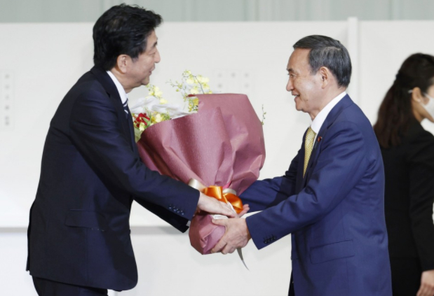 Thủ tướng sắp mãn nhiệm Shinzo Abe tặng hoa Chánh văn phòng Nội các Yoshihide Suga hôm 14 tháng 9 năm 2020. Ảnh: Kyodo