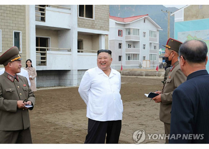 Nhà lãnh đạo Kim Jong-un mỉm cười khi nói chuyện với các quan chức trong chuyến thăm tới địa điểm tái thiết ở Kimhwa, tỉnh Gangwon. Ảnh: Rodong Sinmun