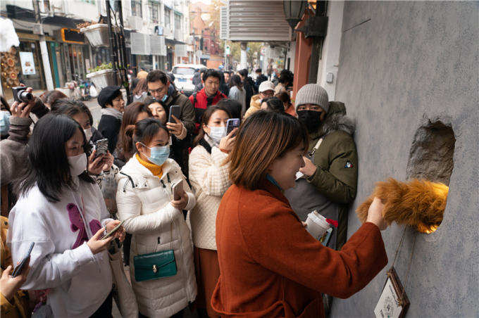 Người dân bắt tay gấu tại quán cà phê Gấu ở Thượng Hải hôm 5 tháng 12. Đây là cửa tiệm cà phê của một số người bị khiếm thính đứng ra kinh doanh nhằm lan tỏa thông điệp về sự ấm áp. Ảnh: Gao Erqiang/China Daily