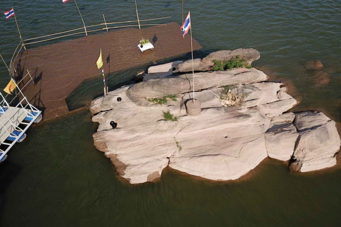 Tảng đá có hình dấu chân Đức Phật năm nay đã nhô lên khỏi mặt nước ở giữa sông Mekong sớm hơn mọi năm. Ảnh: Pattanapong Sripiachai