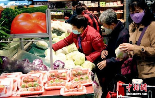 Người dân đeo khẩu trang phòng dịch Covid-19 tranh nhau mua rau củ tại một siêu thị ở thành phố Phúc Châu, tỉnh Phúc Kiến, miền đông nam Trung Quốc hôm 27 tháng 1 năm 2020. Ảnh:  China News Service