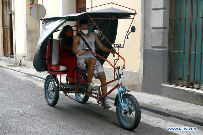 Một phụ nữ đi xe ba bánh thuê do tư nhân sở hữu ở thủ đô Havana, Cuba hôm 12 tháng 2 năm 2021. Ảnh: Joaquin Hernandez