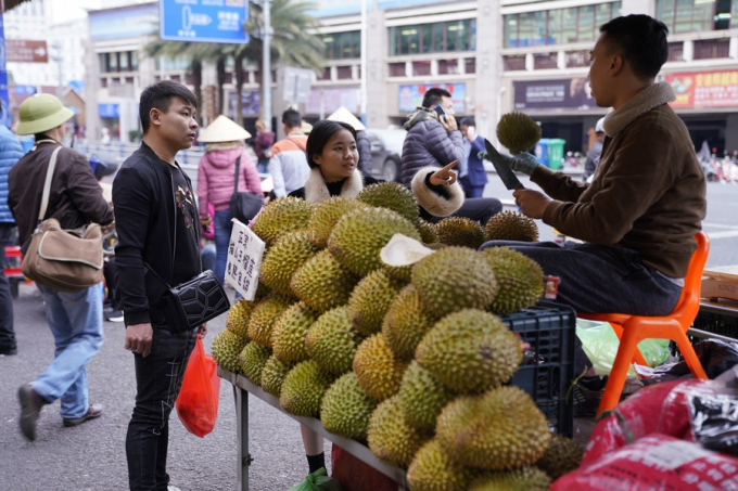 People buy durians from a Vietnamese vendor at Wanzhong International Wholesale Market in Dongxing, south China's Guangxi Zhuang Autonomous Region, Dec. 27, 2019. Photo: Xinhua.