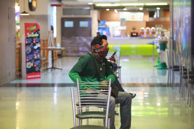 A food delivery man waits for his customer's meal at a shopping centre in Samut Prakan province. (File photo: Somchai Poomlard)