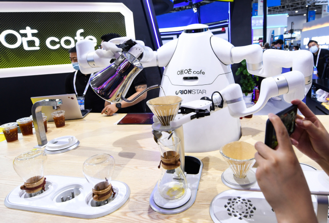 Một con robot trí tuệ nhân tạo (AI) đang pha cà phê và rót vào ly mời khách tại Triển lãm Big Data hôm 26 tháng 5 năm 2021. Ảnh: Tân Hoa xã