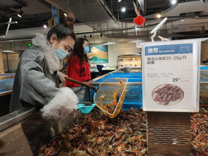 Một khách hàng chọn mua tôm hùm đất tại một chợ hải sản ở thành phố Vũ Hán, thủ phủ tỉnh Hồ Bắc ngày 1 tháng 4 năm 2020. Ảnh: Chinadaily