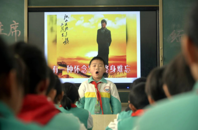 Một học sinh tiểu học ở Liêu Thành, tỉnh Sơn Đông, đọc thuộc lòng một bài thơ về cố Chủ tịch Mao Trạch Đông nhân kỷ niệm 125 năm ngày sinh của ông hồi năm 2018. Ảnh: Reuters