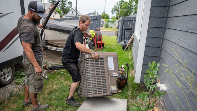 Carl Rocha, left, and Patrick Plummer, with Bills Heating & A/C Install air conditioning and a new furnace at a home on East Wabash Street, June 23, 2021, in Spokane, Wash. With temperatures forecast to hit over 100 degrees by Sunday, a rush of customers are keeping local A/C installers busy. Photo: AP