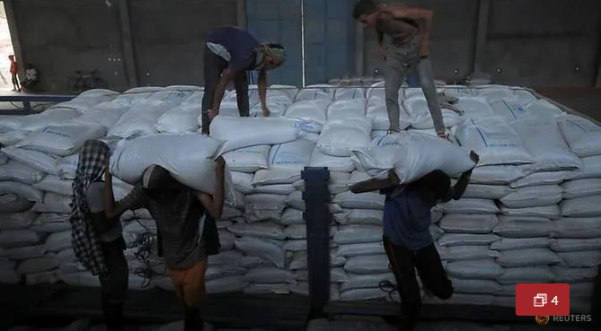 Ethiopian porters unload food aid bound for victims of war after a checkpoint leading to Tigray in Mai Tsebri town, Ethiopia June 26, 2021. 