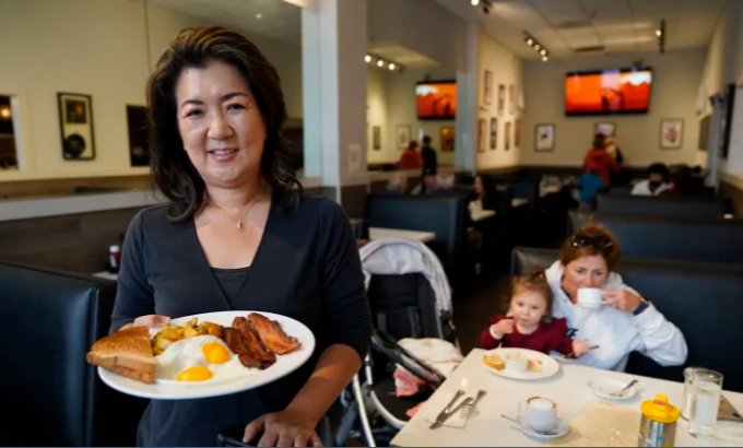 Jeannie Kim holds her popular bacon and eggs breakfast at her restaurant in San Francisco on Friday, July 30, 2021. Thanks to a reworked menu and long hours, Jeannie Kim managed to keep her San Francisco restaurant alive during the coronavirus pandemic. That makes it all the more frustrating that she fears her breakfast-focused diner could be ruined within months by new rules that could make one of her top menu items — bacon — hard to get in California. Photo: AP /Eric Risberg