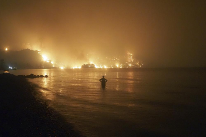  In this file photo dated Friday, Aug. 6, 2021, a man watches as wildfires approach Kochyli beach near Limni village on the island of Evia, about 160 kilometers (100 miles) north of Athens, Greece. A new massive United Nations science report is scheduled for release Monday Aug. 9, 2021, reporting on the impact of global warming due to humans.  Photo: AP