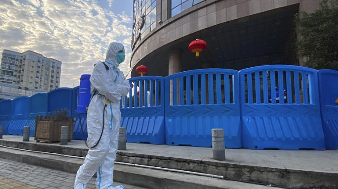 Một nhân viên y tế mặc đồ bảo hộ khử trùng lối đi bộ ở bên ngoài Bệnh viện Trung ương Vũ Hán hôm 6 tháng 2 năm 2021. Ảnh: AP