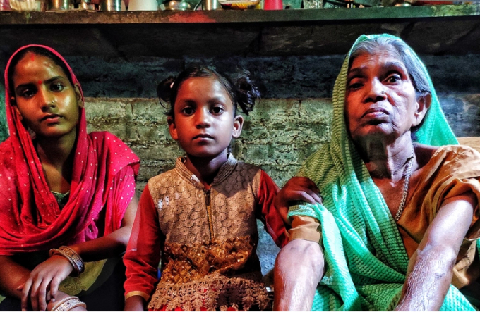 Rani Devi with her two granddaughters at their shanty in New Delhi. Photo: Al Jazeera