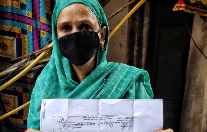 Tabassum Nisha holding her 2013 receipt of her application for a ration card. Photo: Al Jazeera