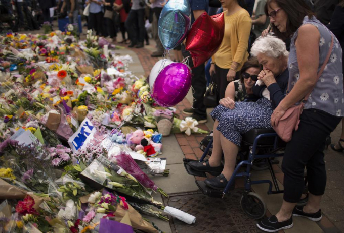 Người dân Anh đặt hoa tưởng niệm các nạn nhân tại quảng trường ở trung tâm thành phố Manchester, sau vụ tấn công liều chết tại một buổi hòa nhạc khiến hơn 20 người chết và nhiều người khác bị thương vào ngày 24 tháng 5 năm 2017. Ảnh: AP