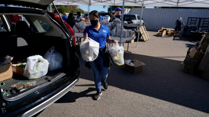 A volunteer loads food into a car at an Armed Services YMCA food distribution, Oct. 28, 2021, in San Diego. As many of 160,000 active duty military members are having trouble feeding their families, according to Feeding America, which coordinates the work of more than 200 food banks around the country. Photo: AP 
