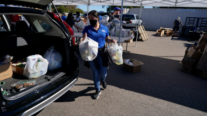 A volunteer loads food into a car at an Armed Services YMCA food distribution, Oct. 28, 2021, in San Diego. As many of 160,000 active duty military members are having trouble feeding their families, according to Feeding America, which coordinates the work of more than 200 food banks around the country. Photo: AP