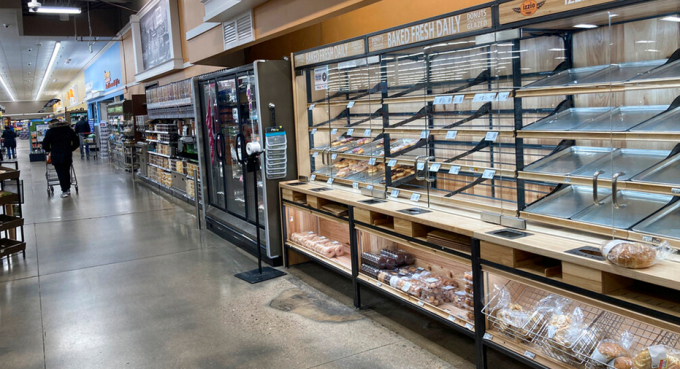 A lone shopper pushes a cart down an empty aisle and past a lightly-stocked donut case in a King Soopers grocery store Friday, Jan. 21, 2022, in southeast Denver. Photo: FB