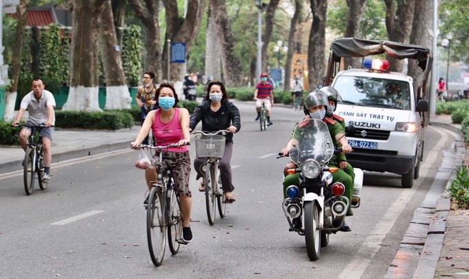 Đội CSGT trật tự, Công an quận Hoàn Kiếm tuần tra kiểm soát, tuyên truyền nhắc nhở người dân chấp hành việc đeo khẩu trang phòng chống lây lan dịch Covid-19. Ảnh: NH.