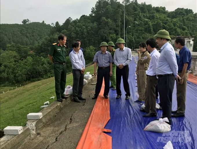 Đơn vị quản lý xử lý sự cố bằng cách che bạt tránh nước mưa ngấm vào vết nứt thân đập, chờ nguồn vốn xử lý khẩn cấp từ UBND tỉnh Thanh Hóa. Ảnh: Công ty TNHH MTV Sông Chu cung cấp.