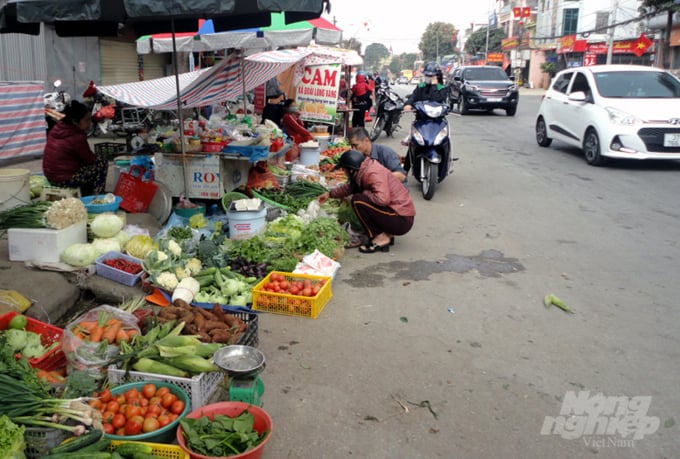 Rau củ quả ở chợ Nghĩa Quang cũng bày bán tràn ra cả đường QL. Ảnh: Hồ Quang.