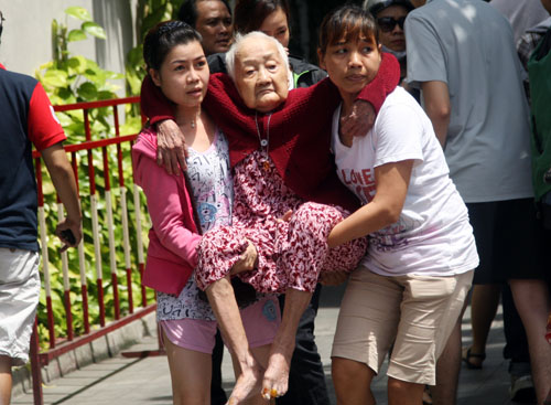 Cụ Nguyễn Thị Hai (94 tuổi) được người nhà bồng từ tầng 21 xuống đất. Ảnh: An Nhơn