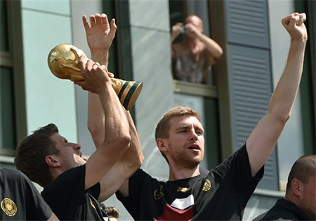 Muller giơ cao chiếc cúp vàng để người hâm mộ Đức được dịp chiêm ngưỡng sau 24 năm chờ đợi