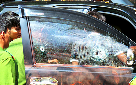 Vết đạn xuyên thủng kính bên phải của chiếc xe ô tô