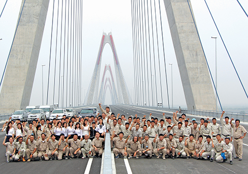 Với kết quả tốt đẹp như ngày hôm nay, niềm vui sướng lớn nhất có lẽ thuộc về những người thợ đã góp sức xây nên cây cầu (Trong ảnh: Các chuyên gia, kỹ sư và công nhân nhà thầu Sumitomo Mitsui, thi công gói thầu số 1, trong ngày cây cầu gần hoàn thiện)