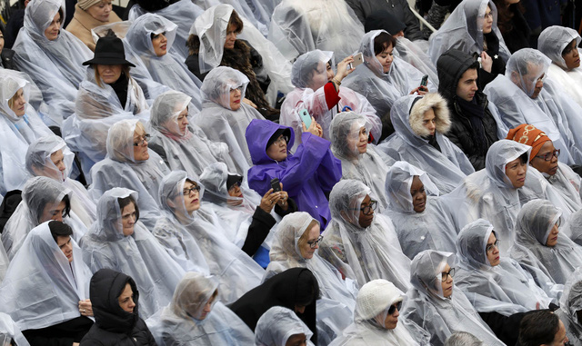 Những người ngồi ở hàng ghế khán giả cũng phải mặc áo mưa trong lúc tham dự lễ nhậm chức của ông Trump.