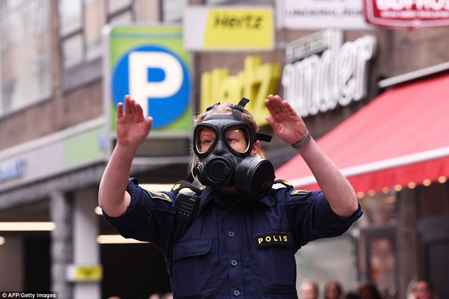   Một cảnh sát đeo mặt nạ khí gần hiện trường vụ tấn công.  