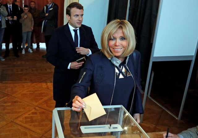 Không chỉ thông minh và sắc sảo, bà Brigitte còn là một người phụ nữ hài hước. Trước sự tò mò và nghi ngại của nhiều người về chuyện tình “chị em” giữa bà và ông Macron, bà Brigitte cho biết bà từng nói với chồng minh rằng nếu ông Macron muốn chạy đua làm tổng thống Pháp thì cần phải sớm thực hiện điều đó, trước khi nhan sắc của bà vẫn chưa tàn phai. Trong ảnh: Bà Brigitte và ông Macron đi bỏ phiếu bầu cử vòng hai tại một điểm bỏ phiếu ở Le Touquet.